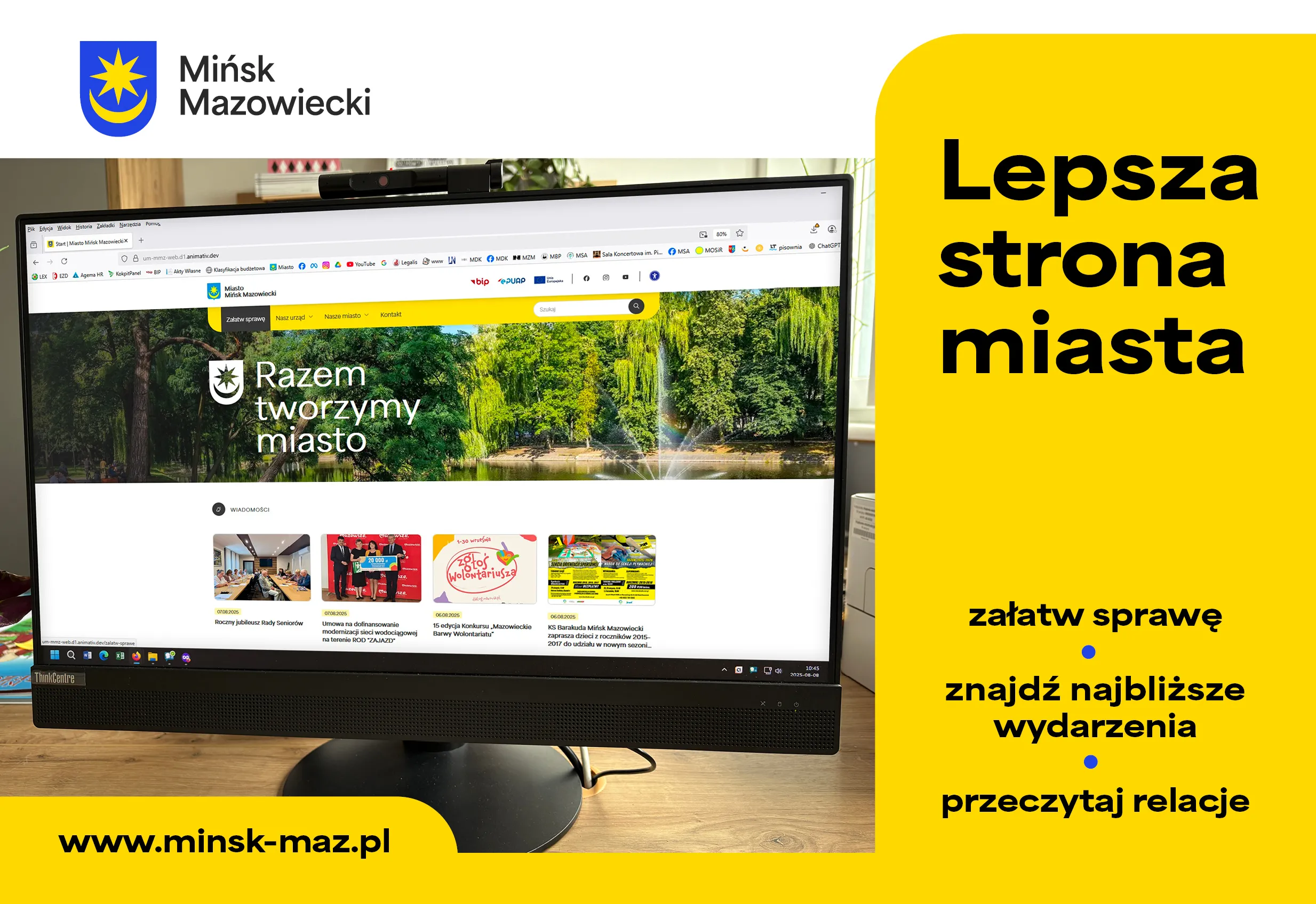 Monitor z otwartą stroną internetową miasta Mińsk Mazowiecki stoi na drewnianym biurku, obok żółta plansza z hasłem Lepsza strona miasta oraz trzema punktami do załatwiania spraw, znajdowania wydarzeń i czytania relacji.