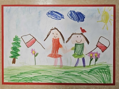 Dwie uśmiechnięte postacie trzymają się za ręce na zielonej łące, każda z nich trzyma flagę Polski. W tle jest zielone drzewo, trzy różowe kwiaty, dwie niebieskie chmury i żółte słońce na niebieskim niebie. Całość jest oprawiona czerwoną ramką.